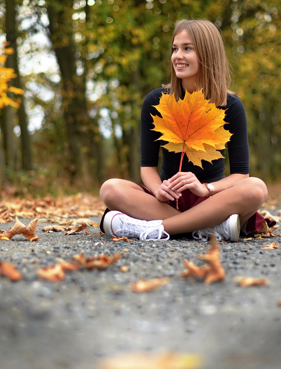 a girl dressed into yellow maple leaves